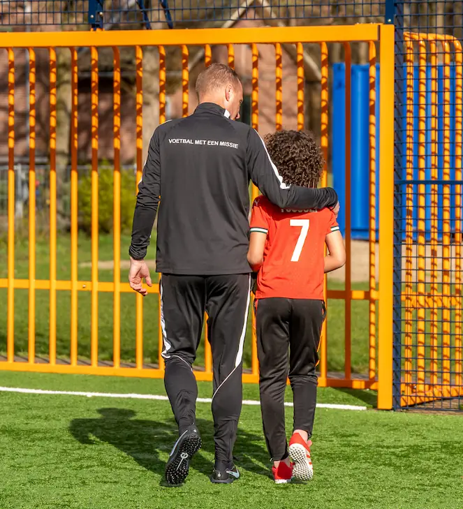 Peter van den Heuvel van Stichting Share & Shine geeft wekelijkse voetbaltraining aan jongeren op een COA AZC locatie